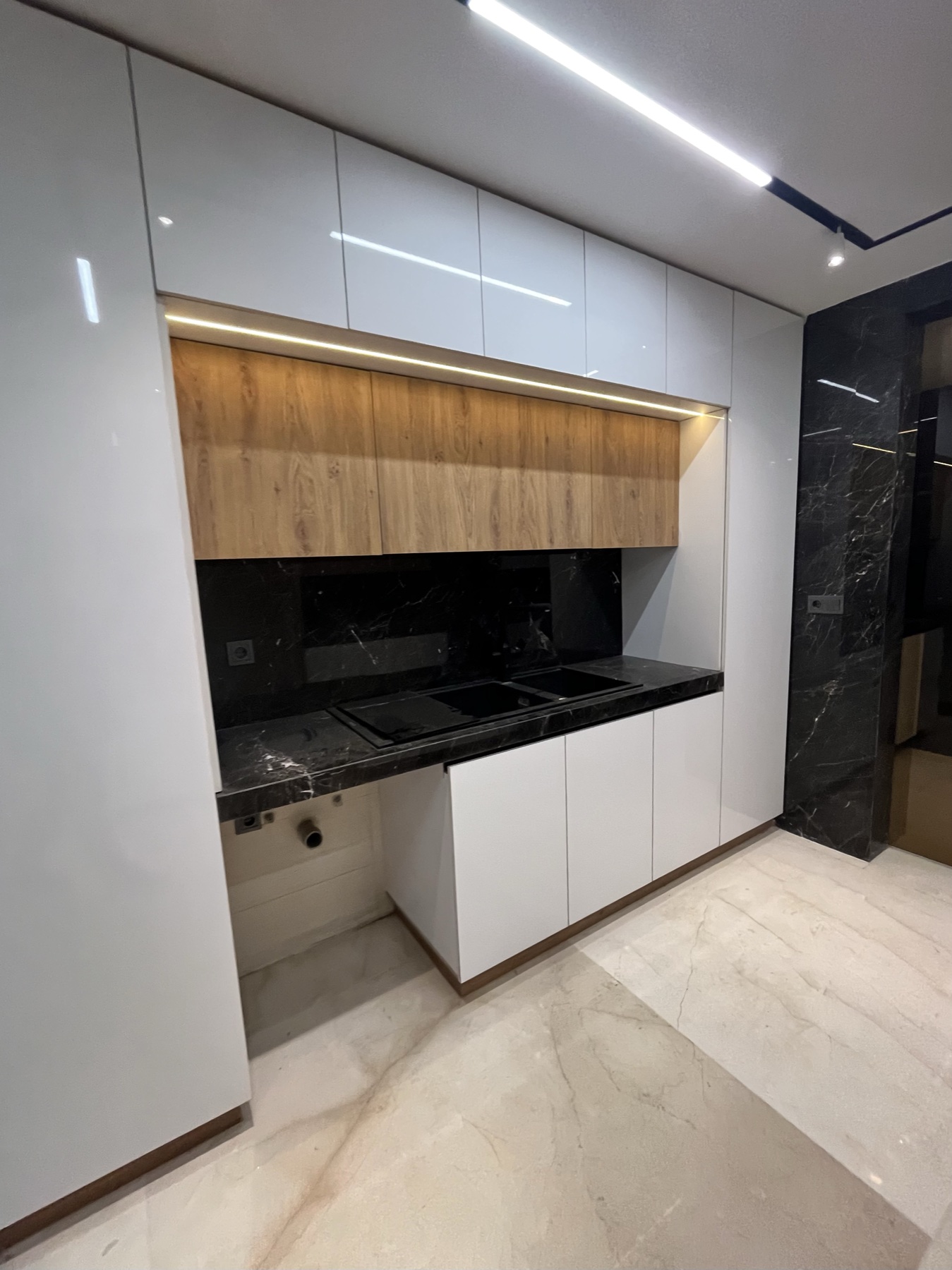 Modern kitchen with black marble countertop and feature wall